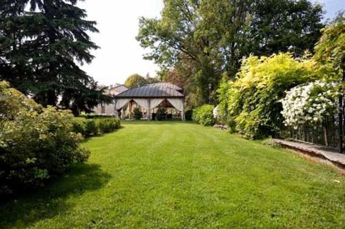 a green yard with a large building in the background at Hotel Villa Beccaris in Monforte dʼAlba