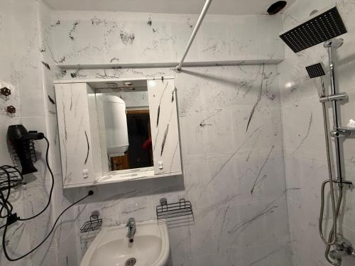 a white bathroom with a sink and a mirror at Liva Konukevi in Ayvalık