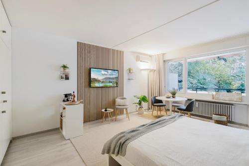a bedroom with a bed and a table and chairs at Charming Suite am Luganersee, Pool, Parkplatz in Bissone