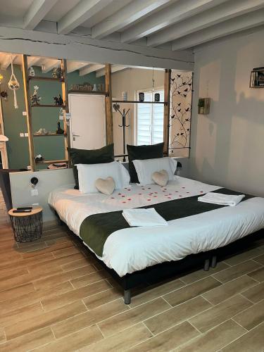 a bedroom with a large bed with red flowers on it at Le Petit Paradis de Marcelise in Le Ponchel