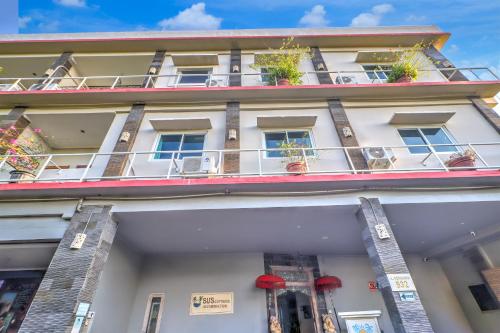 a white building with potted plants on the balconies at Townhouse Oak Su's Cottage Near Legian Beach in Legian
