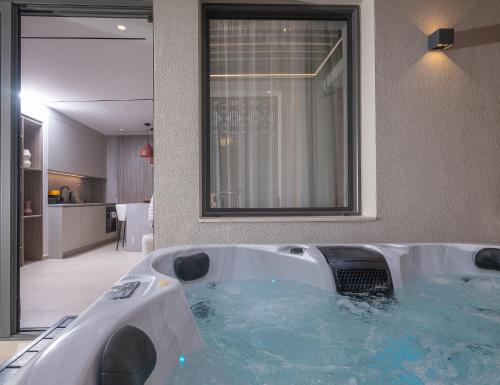 a large bath tub in a bathroom with blue water at Space Row Exclusive Residences in Heraklio