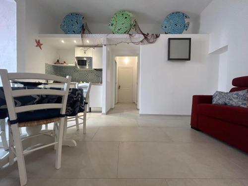 a living room with a table and a red couch at Trame - La Naca sul Porto in Polignano a Mare