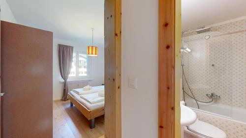 a bathroom with a shower and a bed in a room at Chesa Chatrigna App 9 - Celerina in Celerina