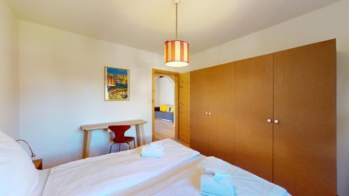 a bedroom with a bed and a desk in it at Chesa Chatrigna App 9 - Celerina in Celerina