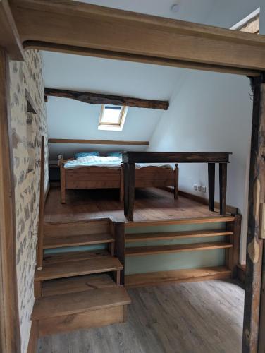 a room with two bunk beds and wooden stairs at Gîte romantique avec charme et confort in Soubrebost