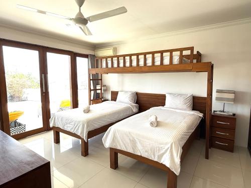 a bedroom with two beds and a bunk bed at Villa Putih in Lovina