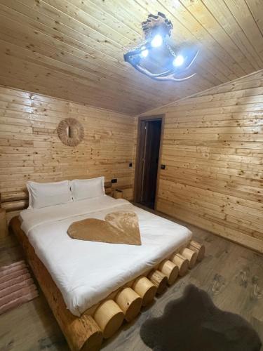 a bedroom with a large bed in a wooden wall at Cabana A Vic in Taşca