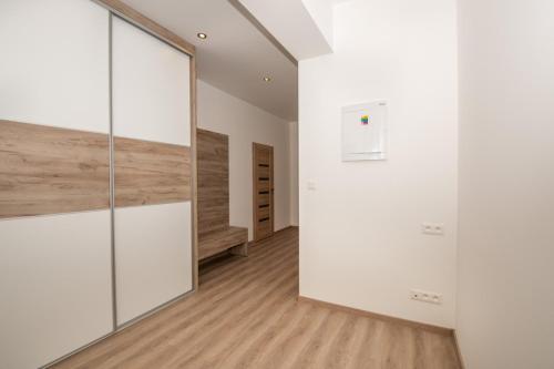 an empty room with white walls and wood floors at Apartmán Istebné luxure in Istebné