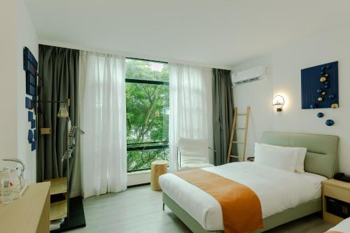 a bedroom with a bed and a large window at city gezhi hotel in Guancun