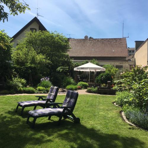 two chairs and a table and an umbrella in a yard at Hotel Restaurant Rebstock in Oppenau