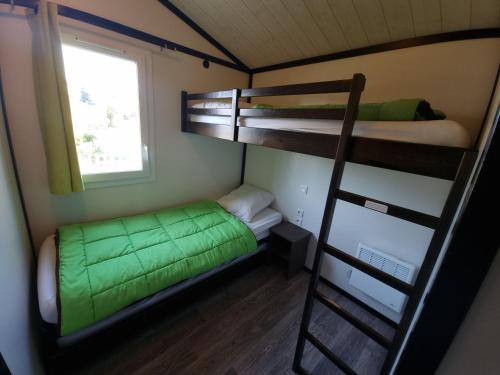 a small room with two bunk beds and a ladder at Camping Les Goélands Carnac in Plouharnel