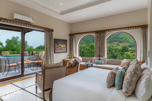 a bedroom with a bed and a living room at Dev Bagh Luxurious Private Suites in Debāri