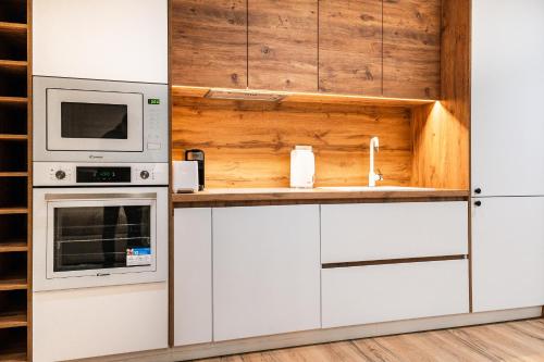 a kitchen with white cabinets and a microwave at Modern Apartment with Balcony & Fast Wi-Fi & Self Check-in in Shkodër