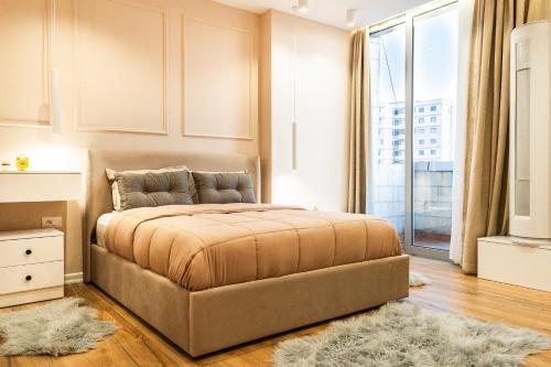a bedroom with a bed and a large window at Modern Apartment with Balcony & Fast Wi-Fi & Self Check-in in Shkodër