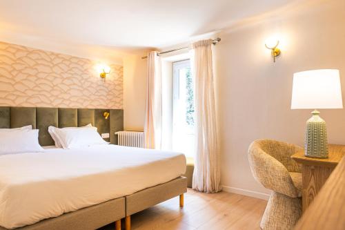a bedroom with a bed and a window at Hôtel Restaurant Le Lachens in La Bastide