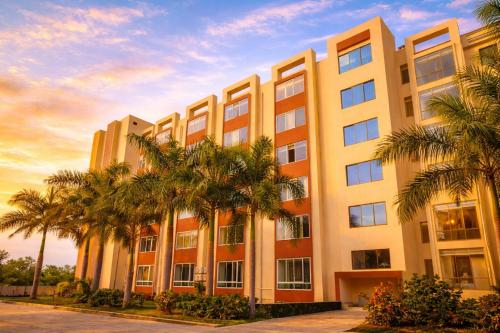 a building with palm trees in front of it at Sairaah Golden Suites, Shirdi in Shirdi