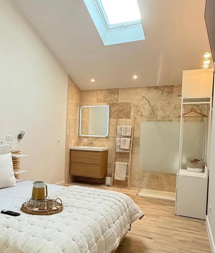 a bedroom with a bed and a bathroom with a sink at Charmants duplex , Clim et Piscine in Aix-en-Provence
