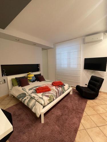 a bedroom with a large bed and a chair at Casa CLEO in Domodossola