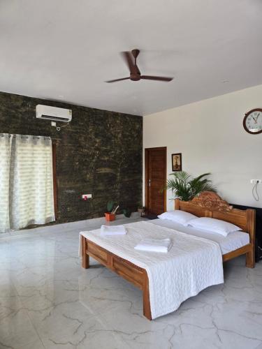 a bedroom with a bed and a ceiling fan at Dsouza Stay in Mysore