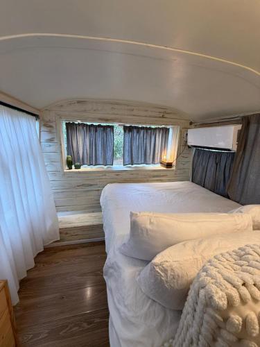 a bedroom with two beds and two windows at צימרים בצפון - קאמפ דיוויד in Sheʼar Yashuv