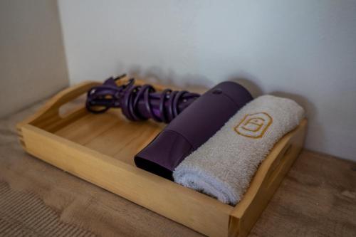 a wooden tray with a purple and white towel at Maha Prana Kedungu by Aayan in Tanah Lot