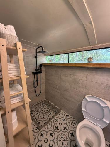 a small bathroom with a toilet and a shower at צימרים בצפון - קאמפ דיוויד in Sheʼar Yashuv