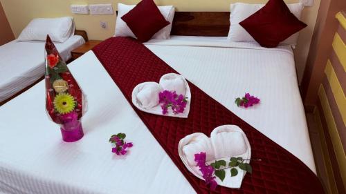 a hotel room with two beds with flowers on them at Hotel Shubham in Karīmnagar