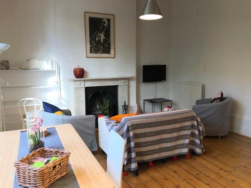 a living room with a couch and a table at Artistic spacious flat in central Brixton in London