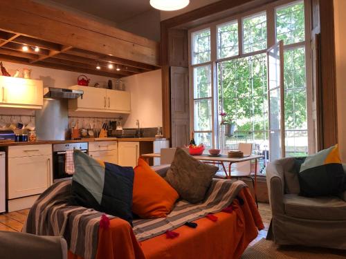 a living room with a couch and a kitchen at Artistic spacious flat in central Brixton in London