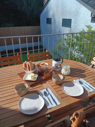 a wooden table with plates of food on a deck at Le refuge des deux âmes in Alby