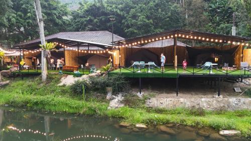 a building with a tent next to a river at Le Rafting & Le Camping in Ban Hin Dan