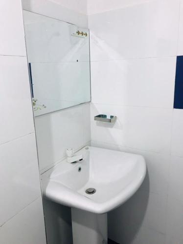 a white bathroom with a sink and a mirror at Galeena Guest in Badulla
