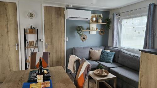 a living room with a couch and a table at Mobilhome Normandie in Litteau