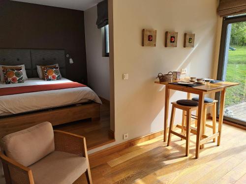 a bedroom with a bed and a desk and a table at La Suite Des Pervenches in Spa