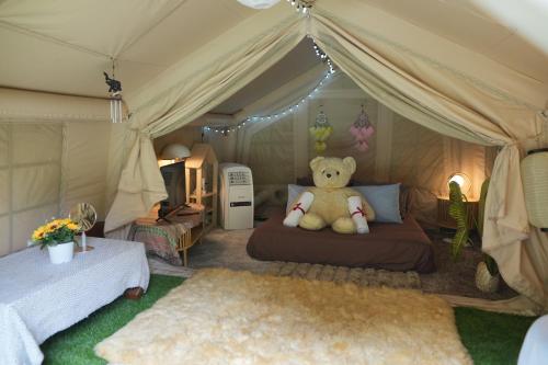 a teddy bear sitting on a bed in a tent at Le Rafting & Le Camping in Ban Hin Dan