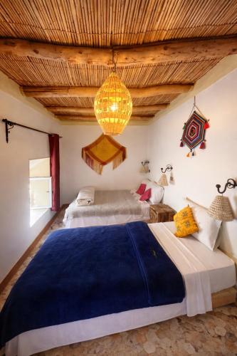 a bedroom with two beds and a chandelier at DAR DANI café restaurant in Boumalne Dades