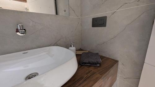 a bathroom with a white toilet and a sink at Prime Suites in Varkala