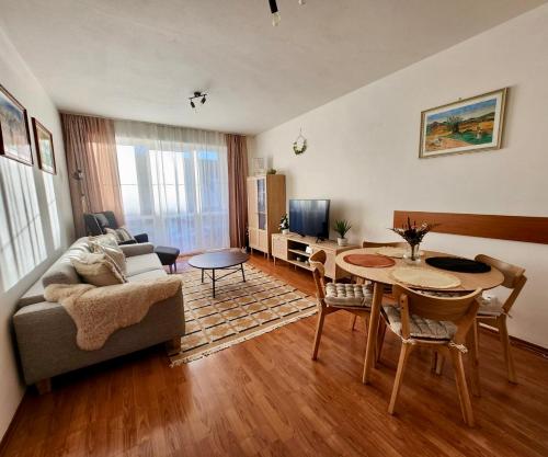 a living room with a couch and a table at Apartmán v centre Donovaly s garážou in Donovaly