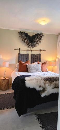 a bedroom with a large bed and two lamps at SAGE Cottage Bloubergstrand in Cape Town