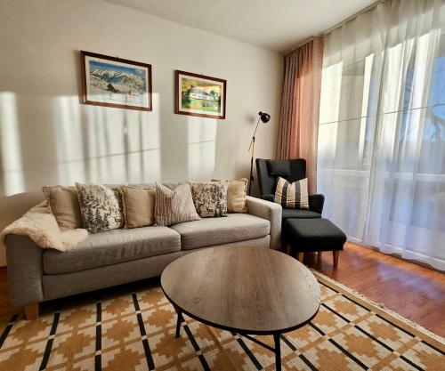 a living room with a couch and a table and a chair at Apartmán v centre Donovaly s garážou in Donovaly