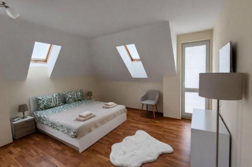 a bedroom with a bed and some skylights at River Park Oasis apartment in Sandanski