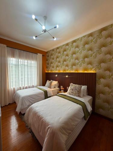a bedroom with two beds and a window with curtains at Townside Estate Room number 10 in Ladysmith