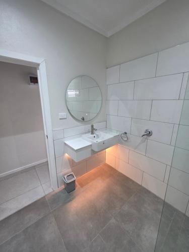 a white bathroom with a sink and a mirror at Savusavu Terraces - Unit 3 in Savusavu