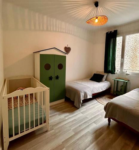 a bedroom with two beds and a crib in it at Chez Stella in Audierne