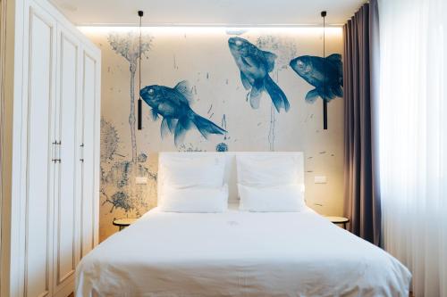 a bedroom with a bed and a painting of fishes at The Kepos Hotel Erlangen in Erlangen