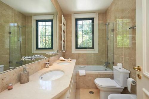 uma casa de banho com um WC, um lavatório e uma banheira em Villa Rio Seco em Sintra