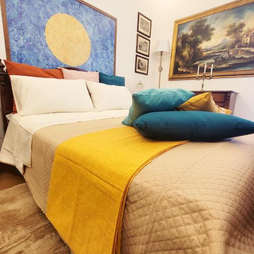 a bed with colorful pillows on top of it at Suite Ekaterina Sunsets 2 minuti dal mare in Brolo