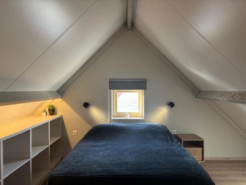 a bedroom with a blue bed in a attic at Vitamin Sea in Oostduinkerke