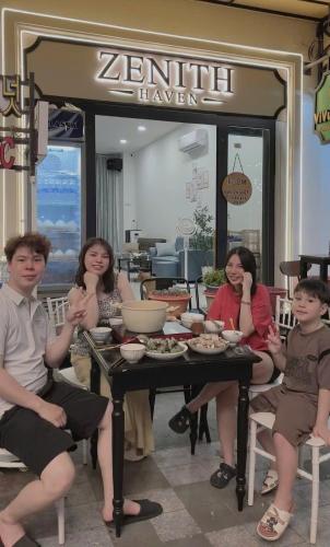 a group of people sitting around a table at Zenith Haven - Boutique Stay in Phú Quốc